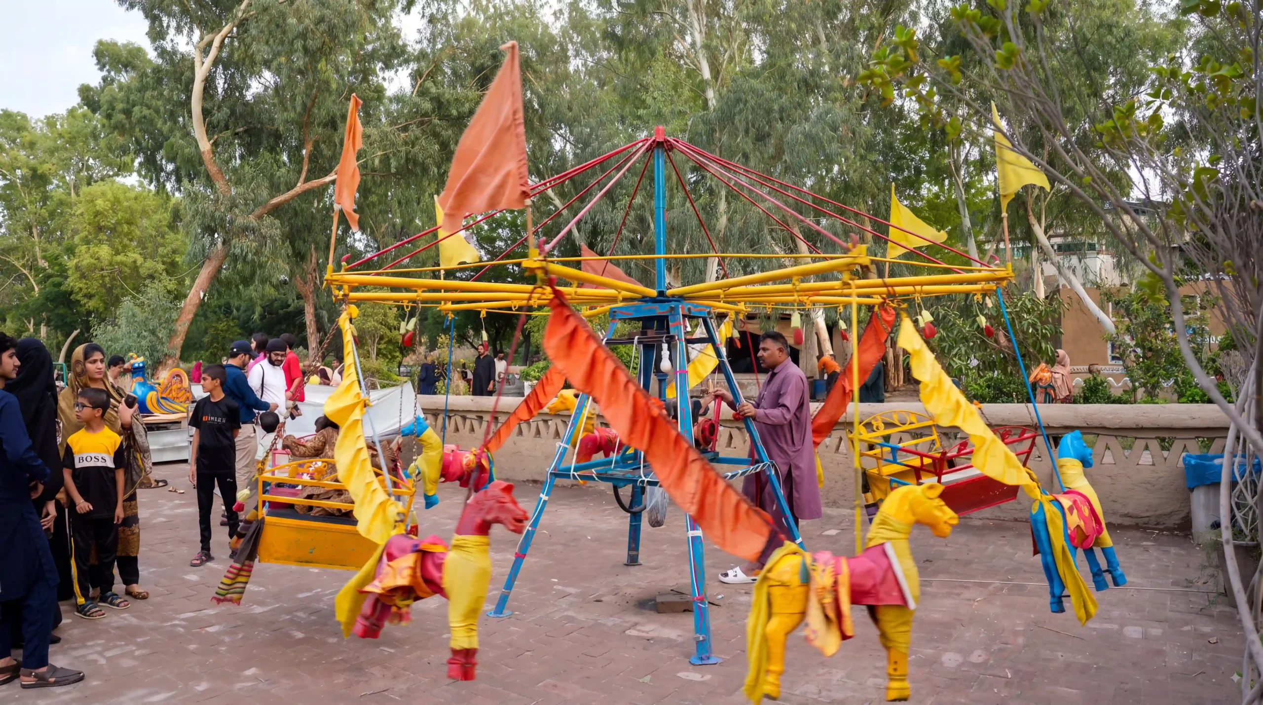 Traditional hand-carved horse swings ride for children in outdoor park