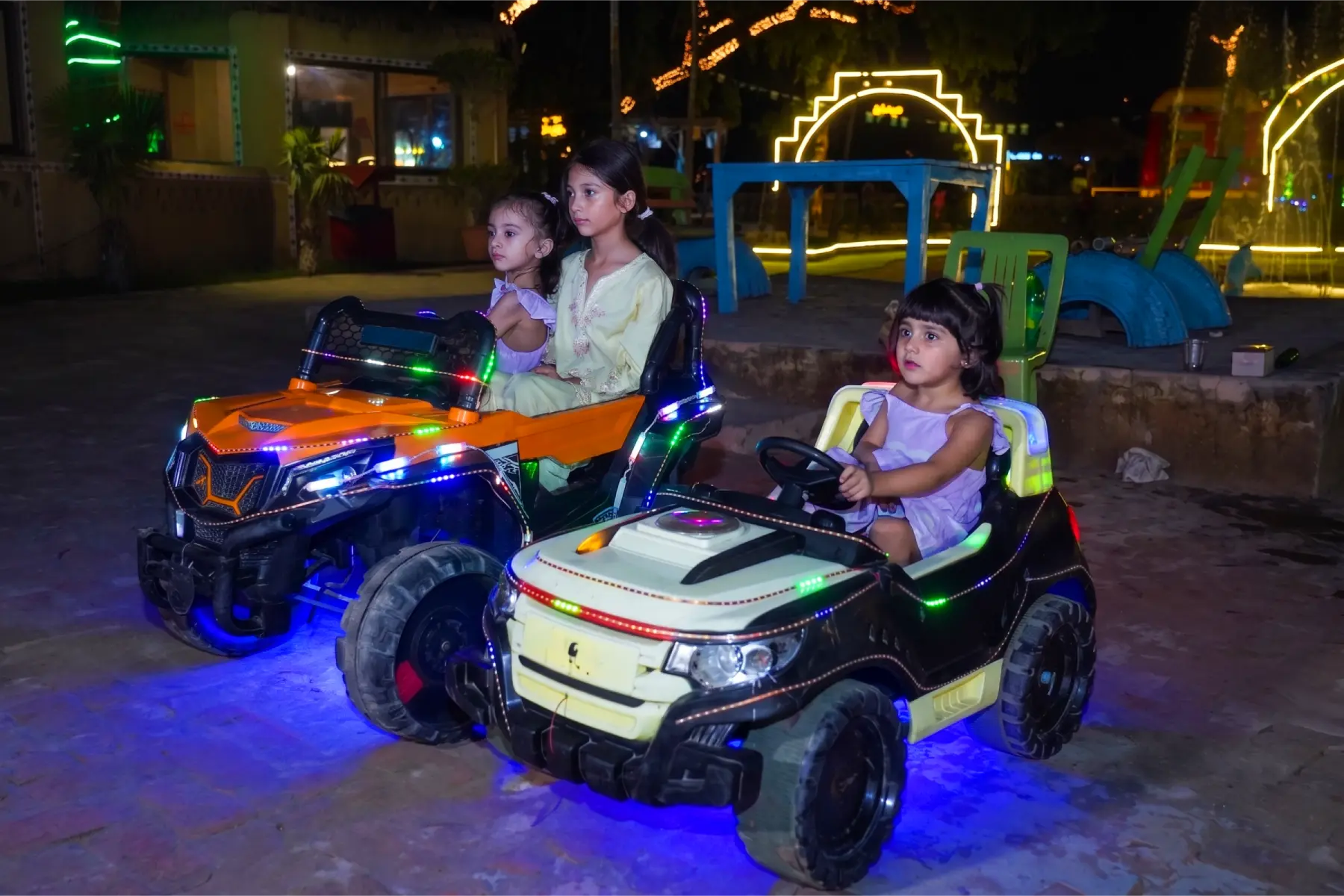 Parents helping children ride electric cars