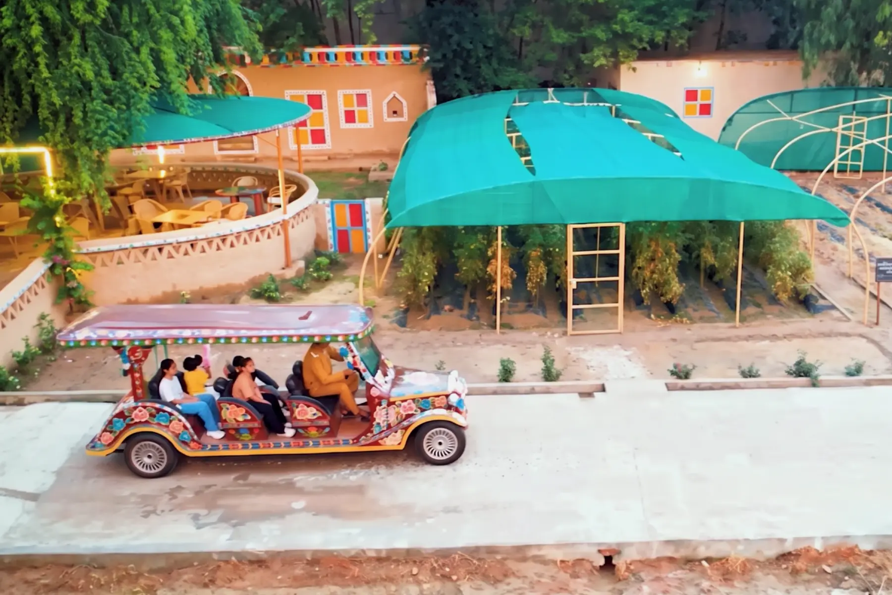Detailed side view of the truck art golf cart parked beside a large banyan tree