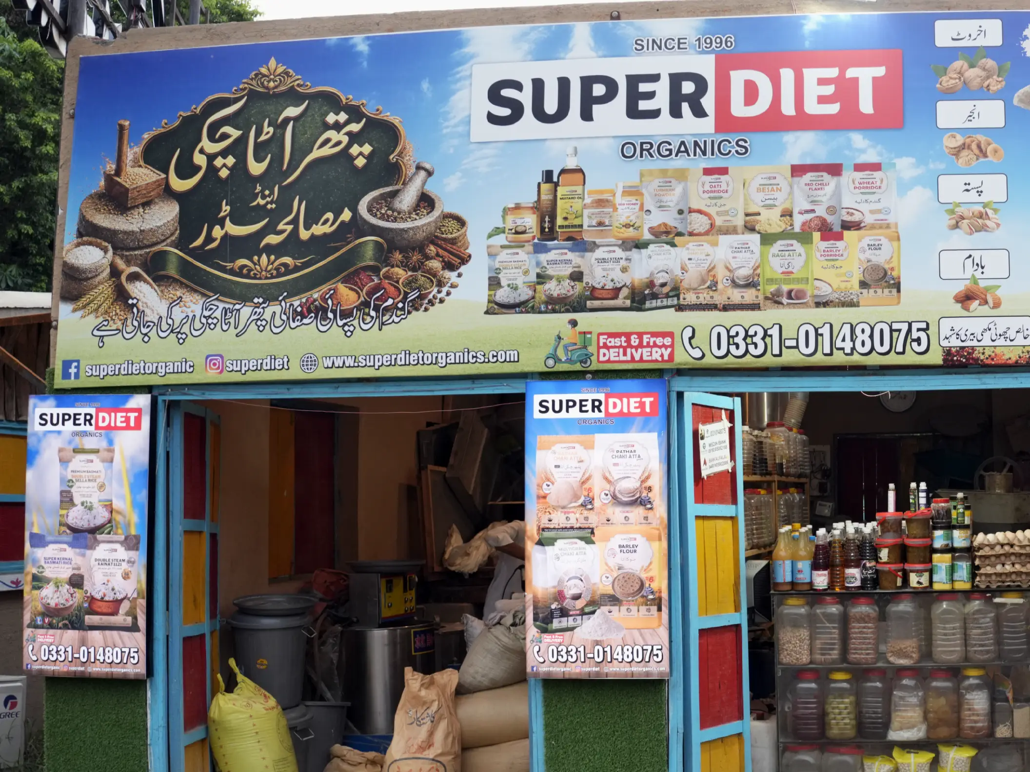 Storefront of Super Diet Organics featuring a large Patthar Atta Chakki signboard and flour sacks.