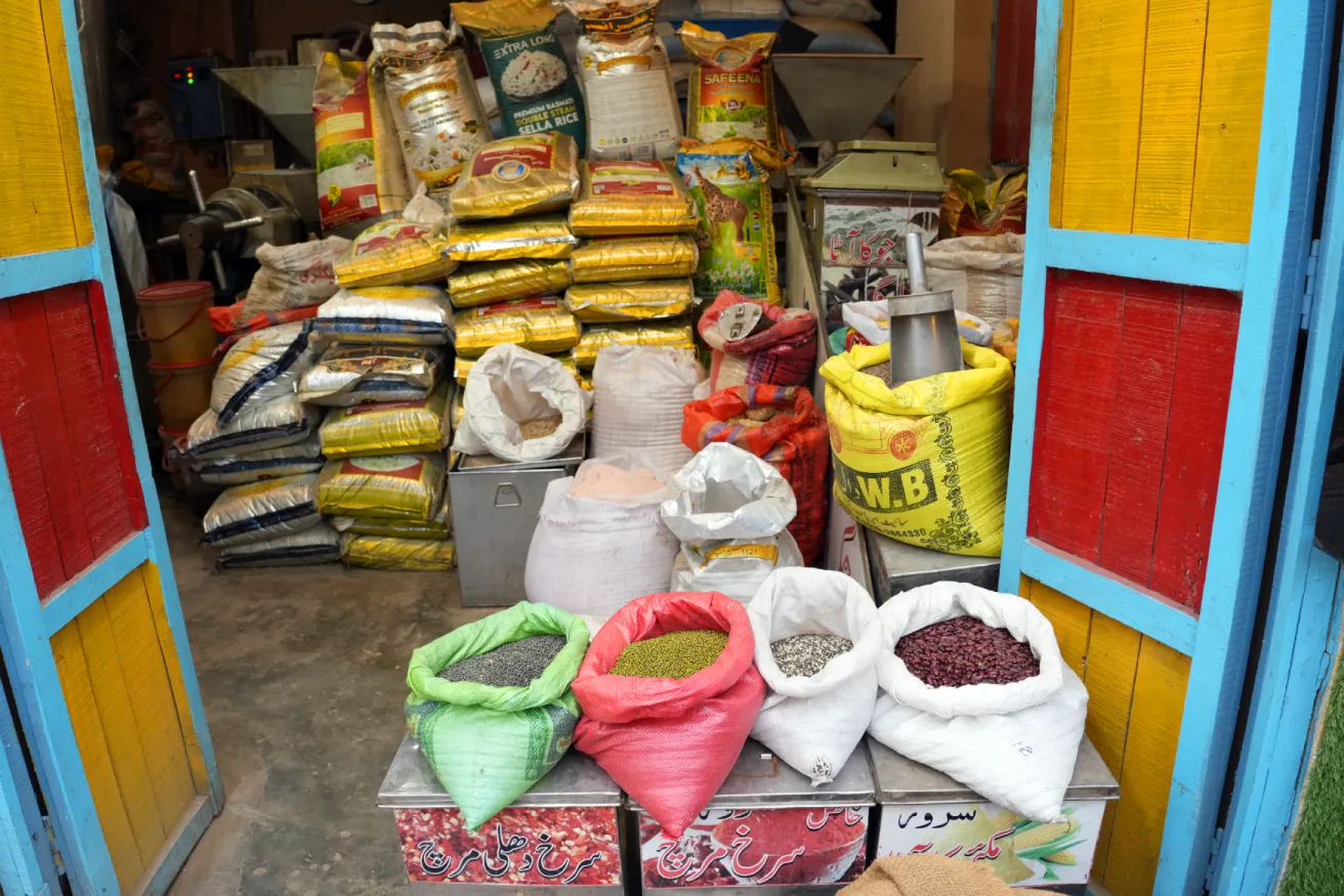 Open sacks of colorful grains and stacked bags inside a 